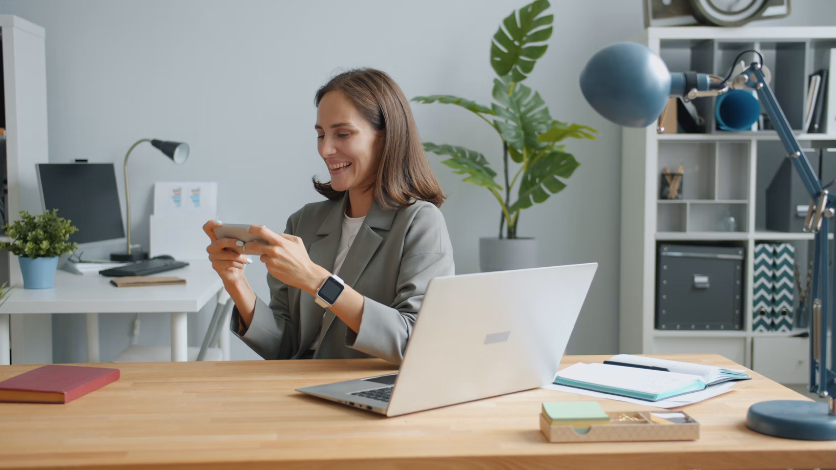 A member happily checking provider options on her phone at her desk